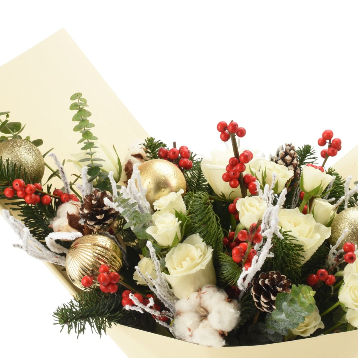 White roses, red berries, gold ornaments, pinecones, cotton, and frosted greenery in elegant cream wrap.