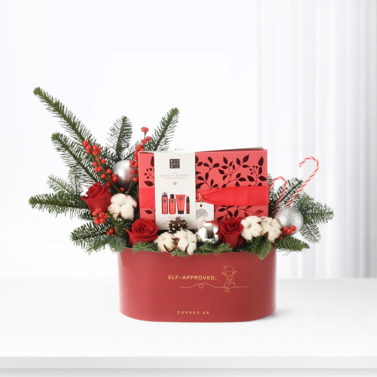 Red holiday gift basket with festive greenery, roses, and "Elf-Approved" branding.