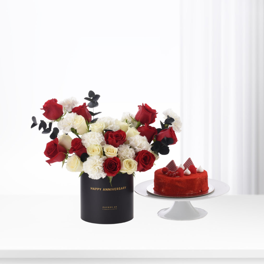 Elegant red, white roses and cake in black anniversary vase.