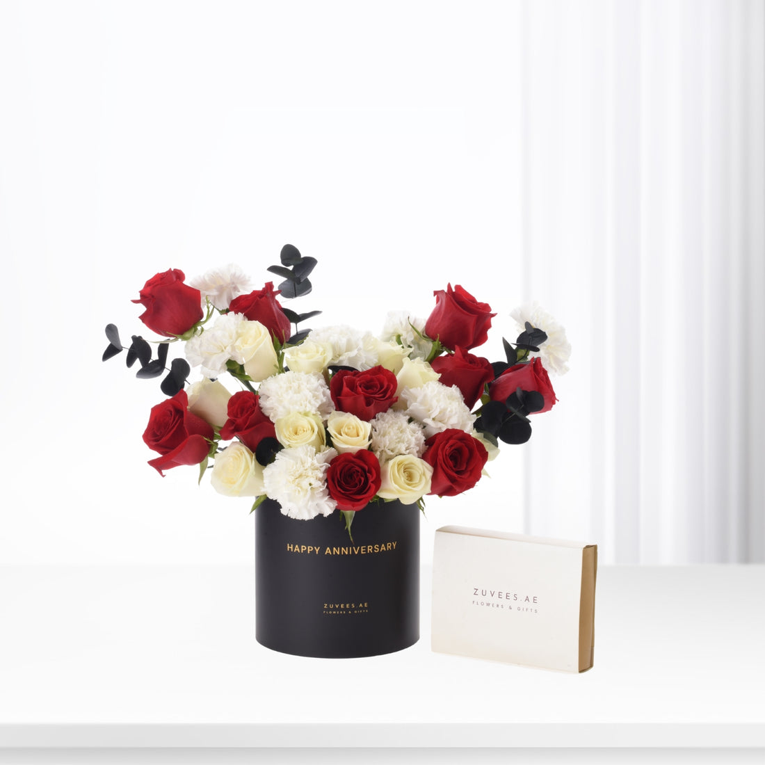 Red and white roses with eucalyptus in black "Happy Anniversary" box, elegant gift set.