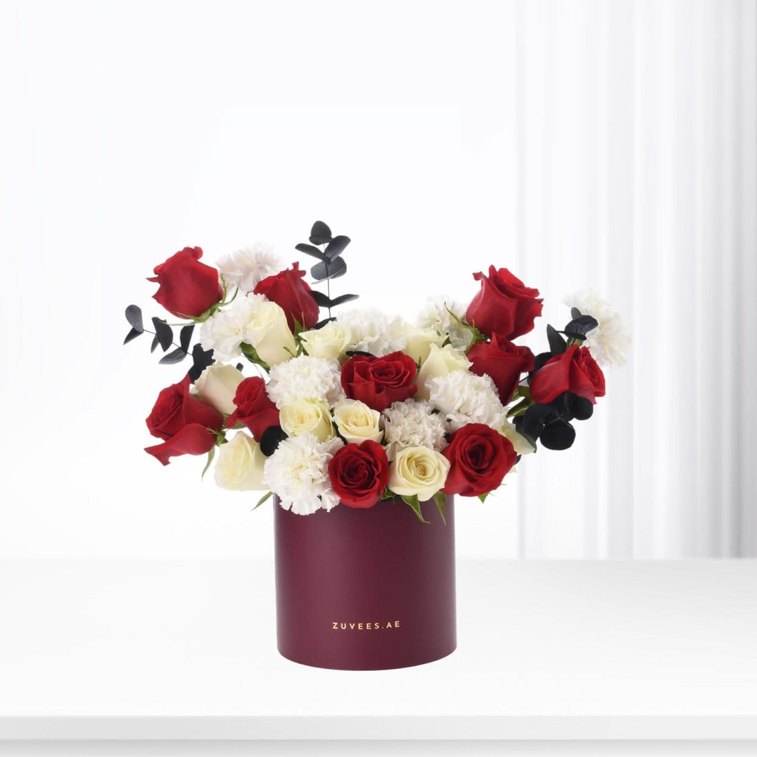 Elegant red, white roses and carnations in matte burgundy box.
