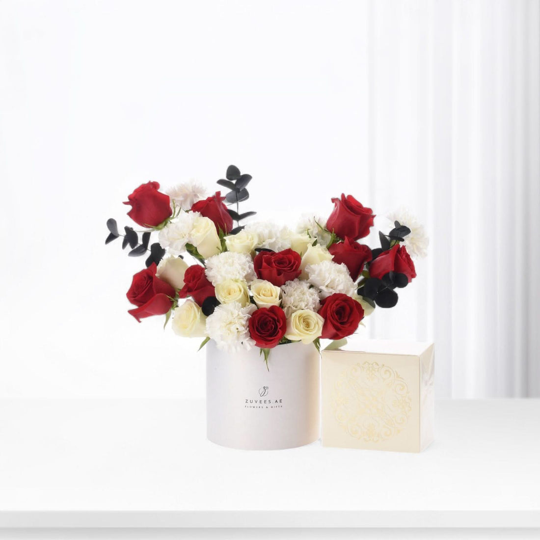 Elegant red, white roses and carnations in minimalist white box with gold-embossed gift box.