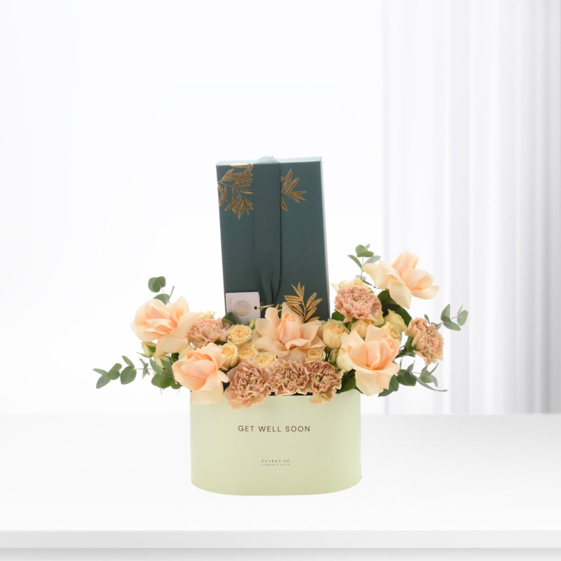 Pastel peach roses and carnations in mint box with "Get Well Soon" message.