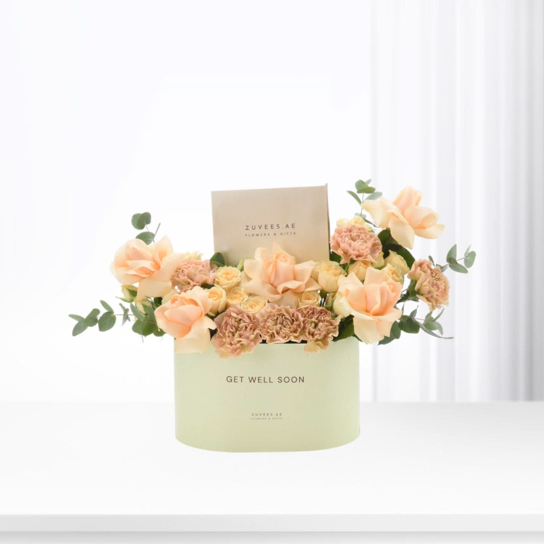 Pastel peach roses and carnations in mint-green "Get Well Soon" box.