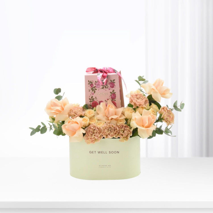 Pastel peach roses and carnations in mint box with "Get Well Soon" message.