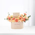 Pastel peach roses and carnations in cream box with "Happy Birthday" message.