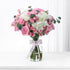 Pink roses and white hydrangeas in clear vase with branded ribbon.