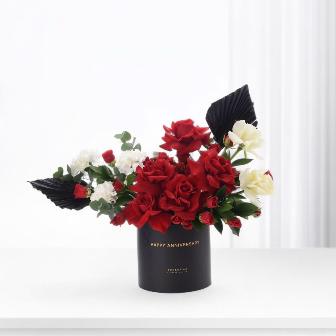 Elegant black vase with red and white roses, "Happy Anniversary" text, modern design.