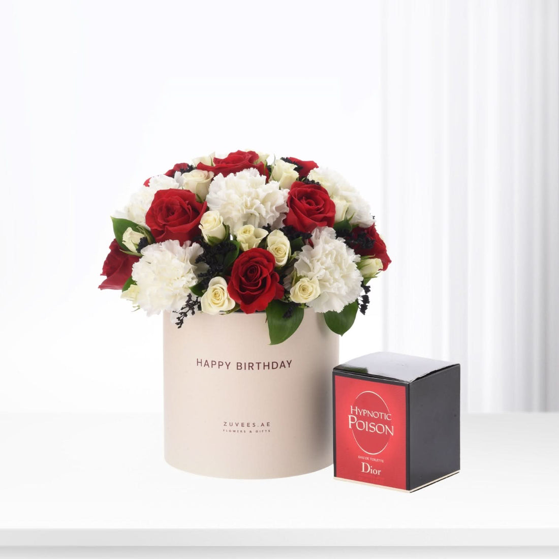 Red and white roses with carnations in beige "Happy Birthday" box, beside Dior Hypnotic Poison perfume.