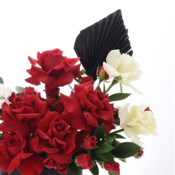 Vibrant red roses contrast elegantly with white blooms and dramatic black fan accents.