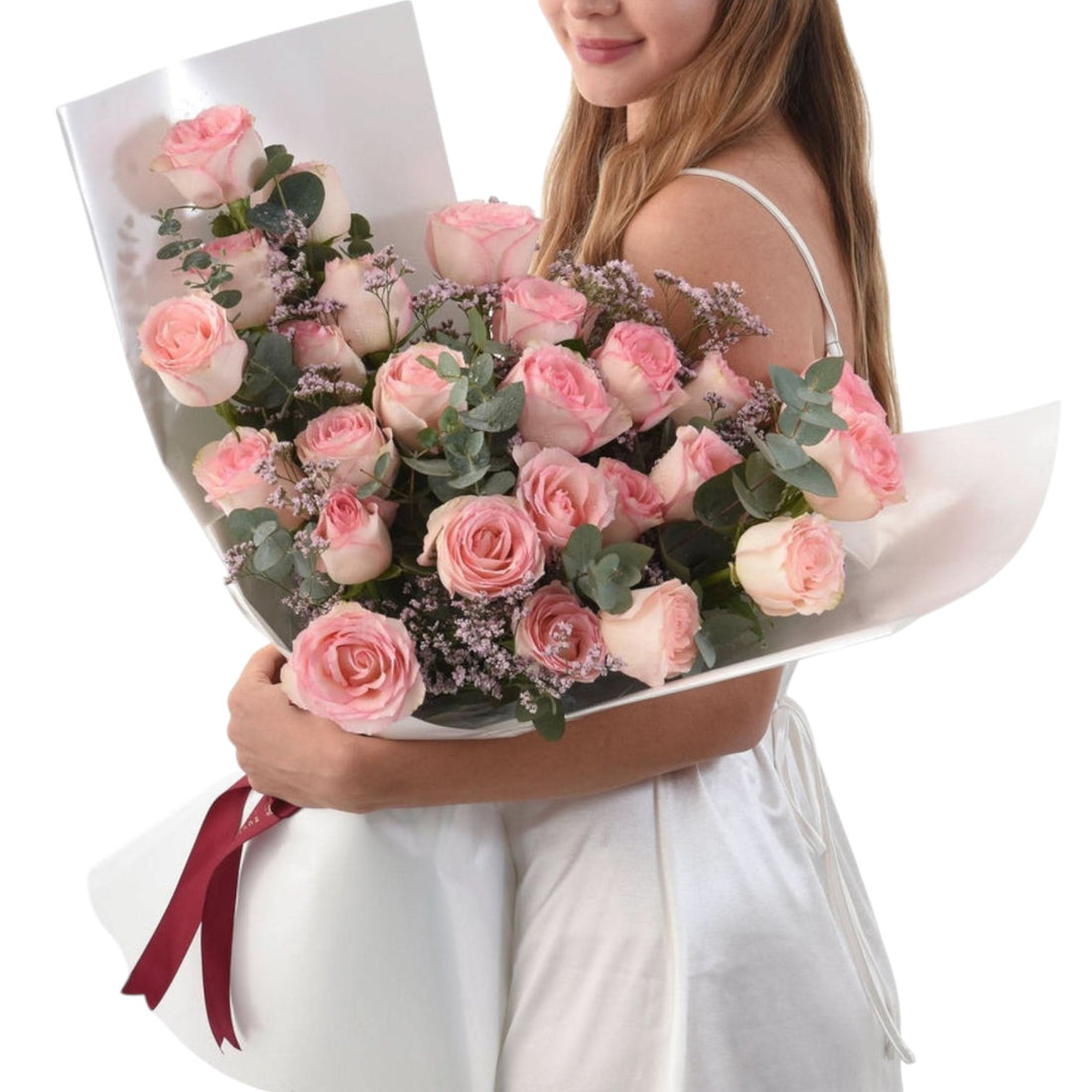 Pink roses, eucalyptus, baby’s breath bouquet wrapped in white paper with red ribbon.