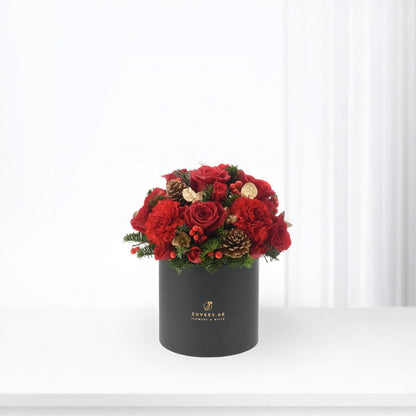 Vibrant red roses and carnations in sleek black box with gold accents.