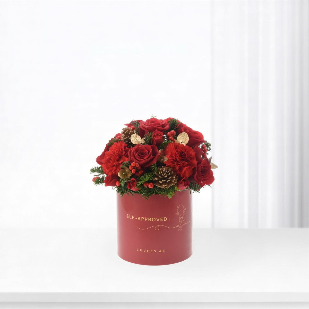 Vibrant red roses and berries in festive red box with gold “Elf-Approved” text.