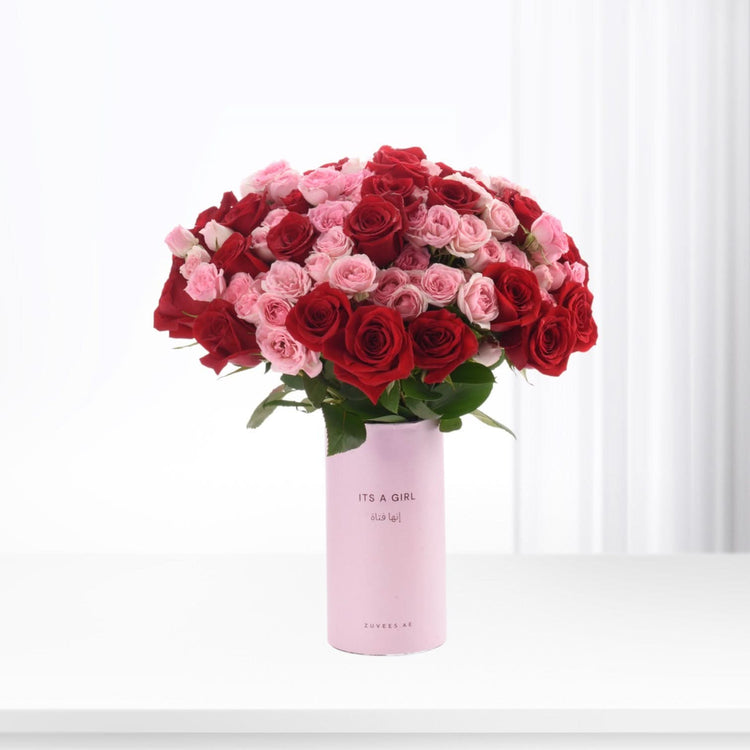 Vibrant red and pink roses in light pink “It’s a Girl” vase.