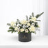 Elegant white floral arrangement with silver ornaments in sleek black box.