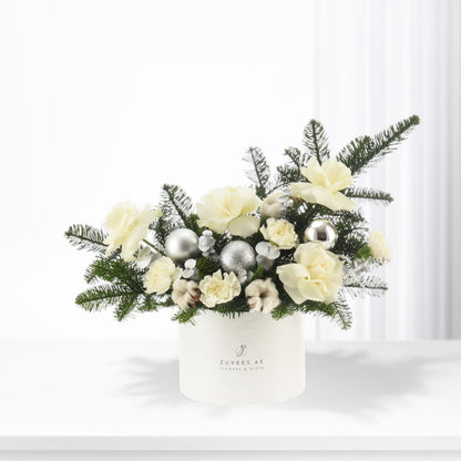 Elegant white floral arrangement with silver ornaments in branded box.