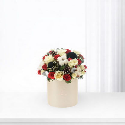 Elegant red and cream roses with pinecones, cotton, and ornaments in beige box.