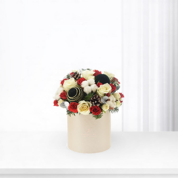 Elegant red and cream roses with pinecones, cotton, and ornaments in beige box.