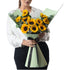 Vibrant sunflowers in mint-green wrap, tied with black ribbon.