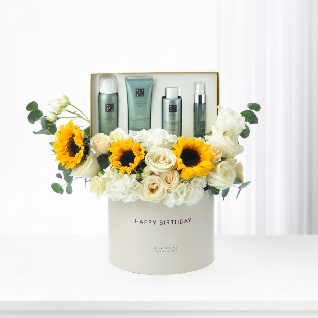 White box with "Happy Birthday," sunflowers, roses, and Rituals skincare set.