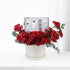 Luxurious red roses cascade around a white gift box with Rituals skincare, elegantly presented.