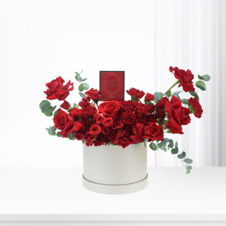 Luxurious red roses, carnations, eucalyptus in white box with Dior Hypnotic Poison perfume.