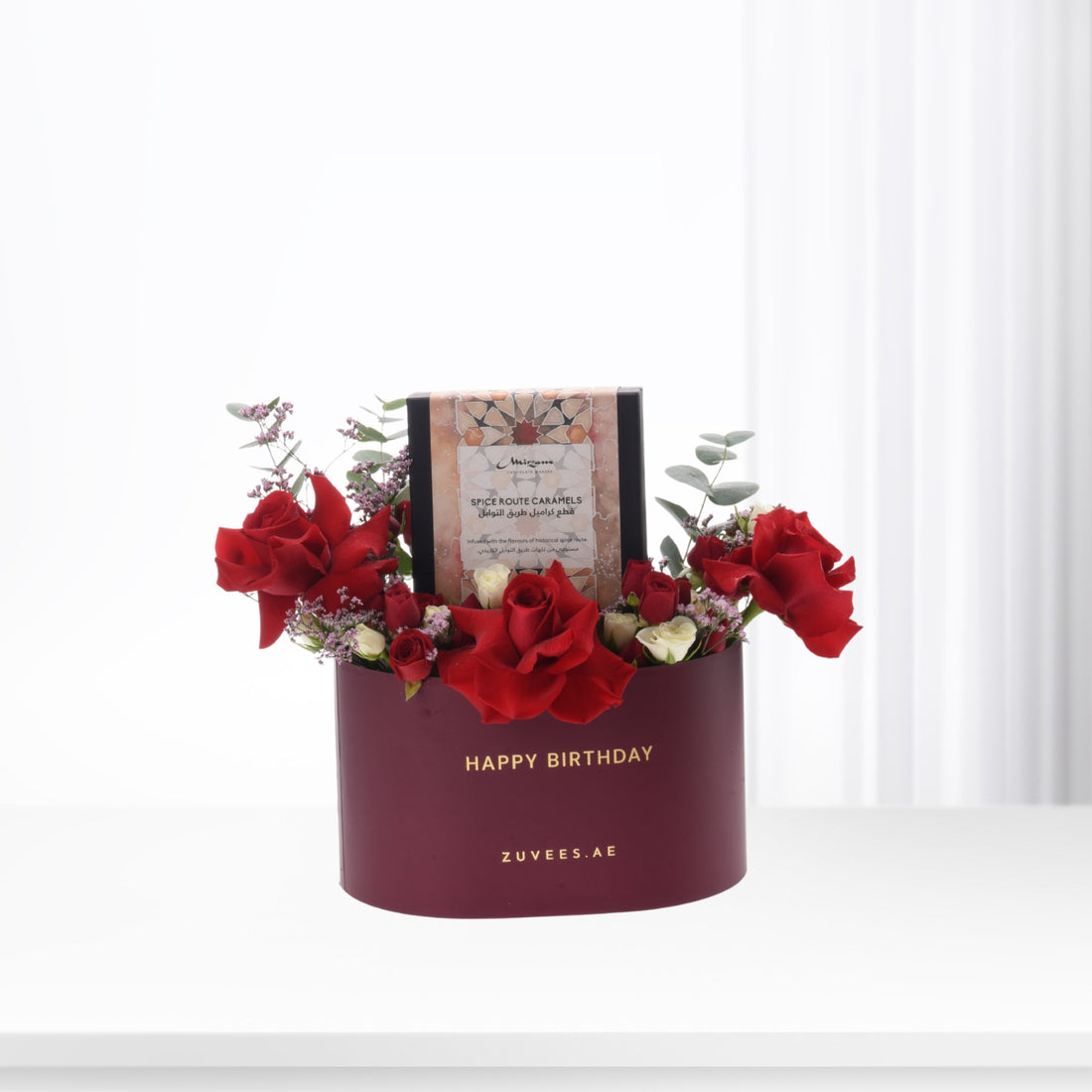Luxurious burgundy birthday box with red roses and spice caramel gift.