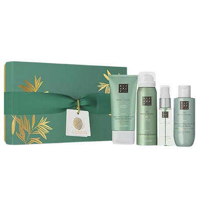 Emerald-green gift box with gold leaf accents holds four matching spa skincare products.