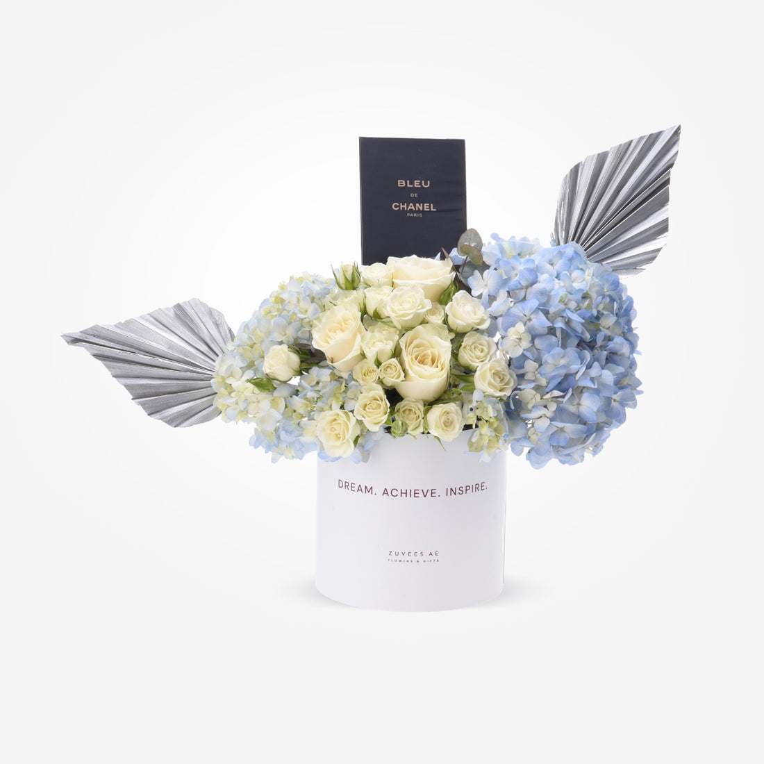 Elegant blue hydrangeas and cream roses in white box with silver wings and Chanel perfume.