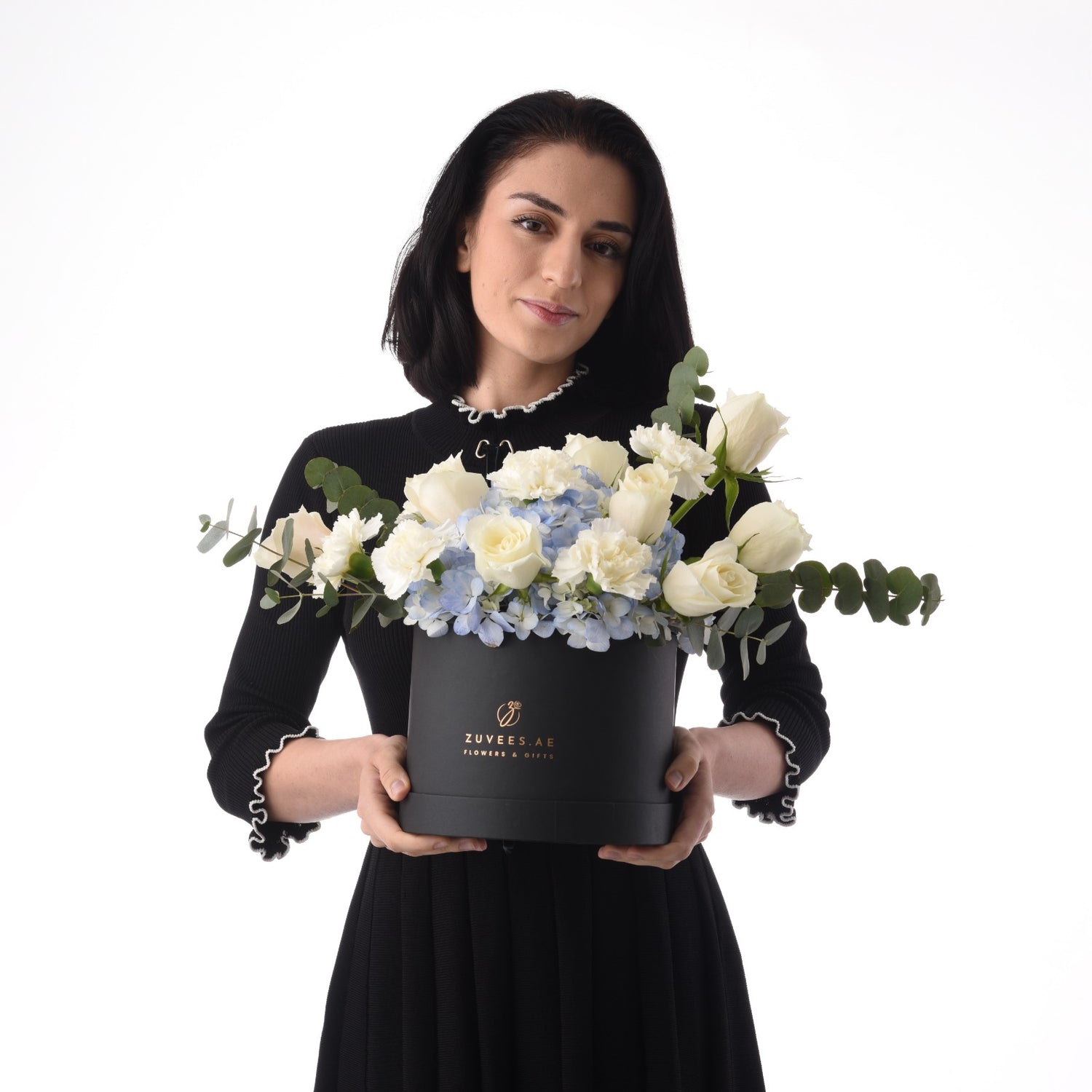Elegant black box holds white roses and blue hydrangeas, accented with eucalyptus.