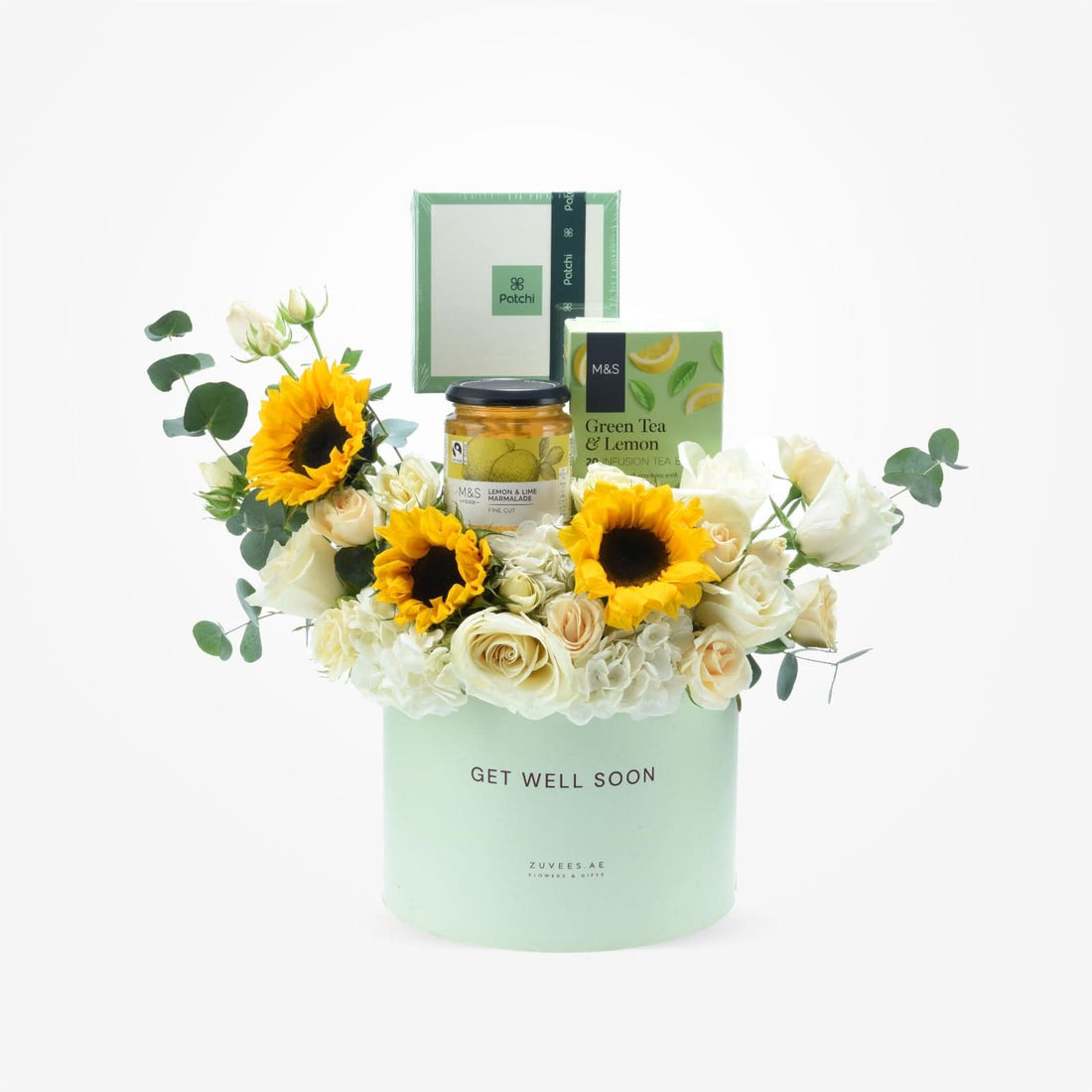Pastel green box holds sunflowers, white roses, and tea marmalade for get-well-soon gift.