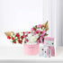 Pink floral arrangement with gold accents and luxury skincare set.