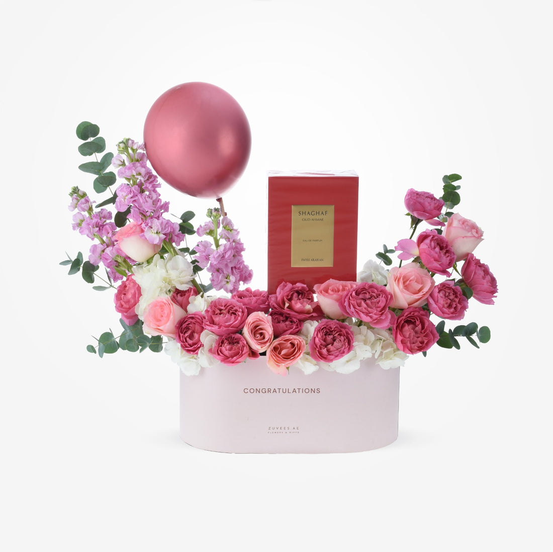 Pink floral arrangement with rose perfume and balloon in celebratory box.