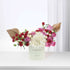 Pastel green vase holds vibrant red, pink, and white roses with gold fan accents.