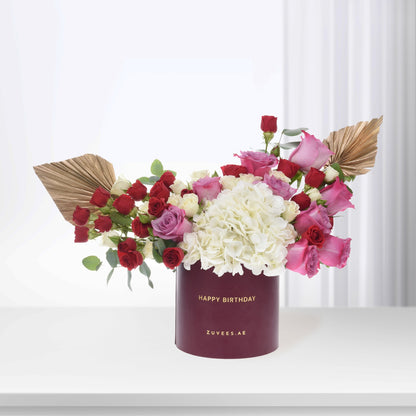Luxury birthday bouquet: red, pink, white roses &amp; hydrangeas in burgundy box with gold text.