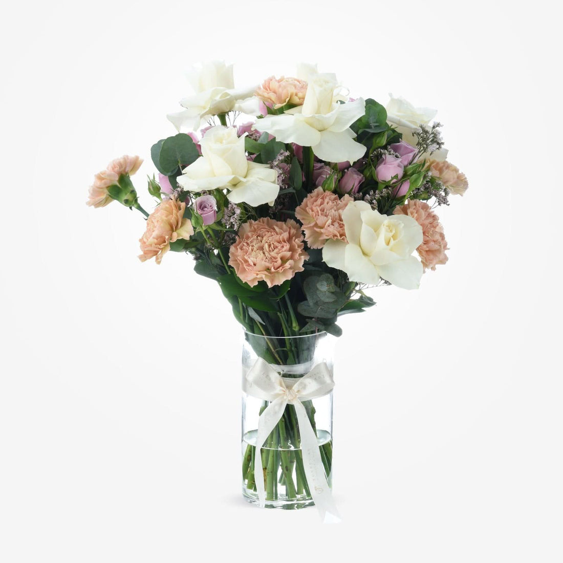 Elegant pastel bouquet in clear vase with cream bow.