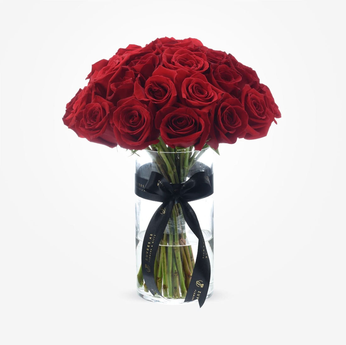 Vibrant red roses in clear glass vase, elegantly tied with black ribbon.