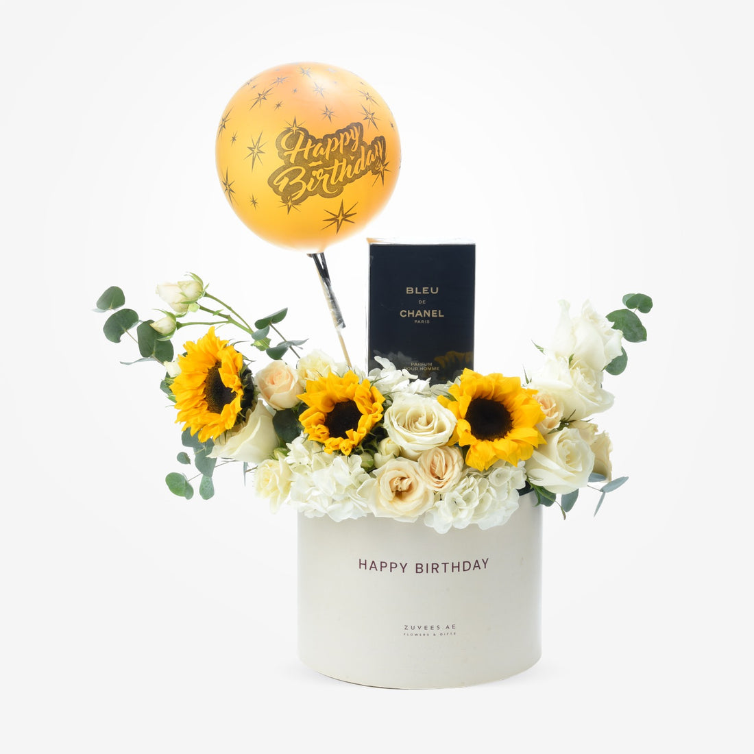 White box holds sunflowers, roses, and Chanel perfume with golden birthday balloon.
