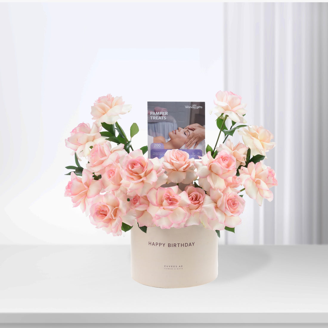Soft pink roses in cream vase with "Happy Birthday" and pamper treats card.