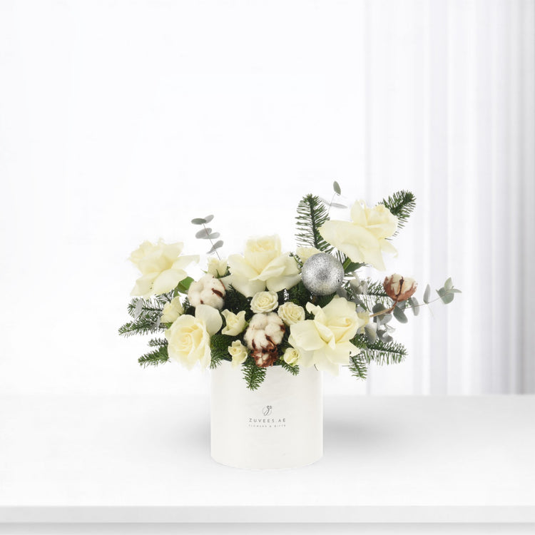Elegant white roses, cotton, eucalyptus, pine, silver ornament in minimalist white vase.