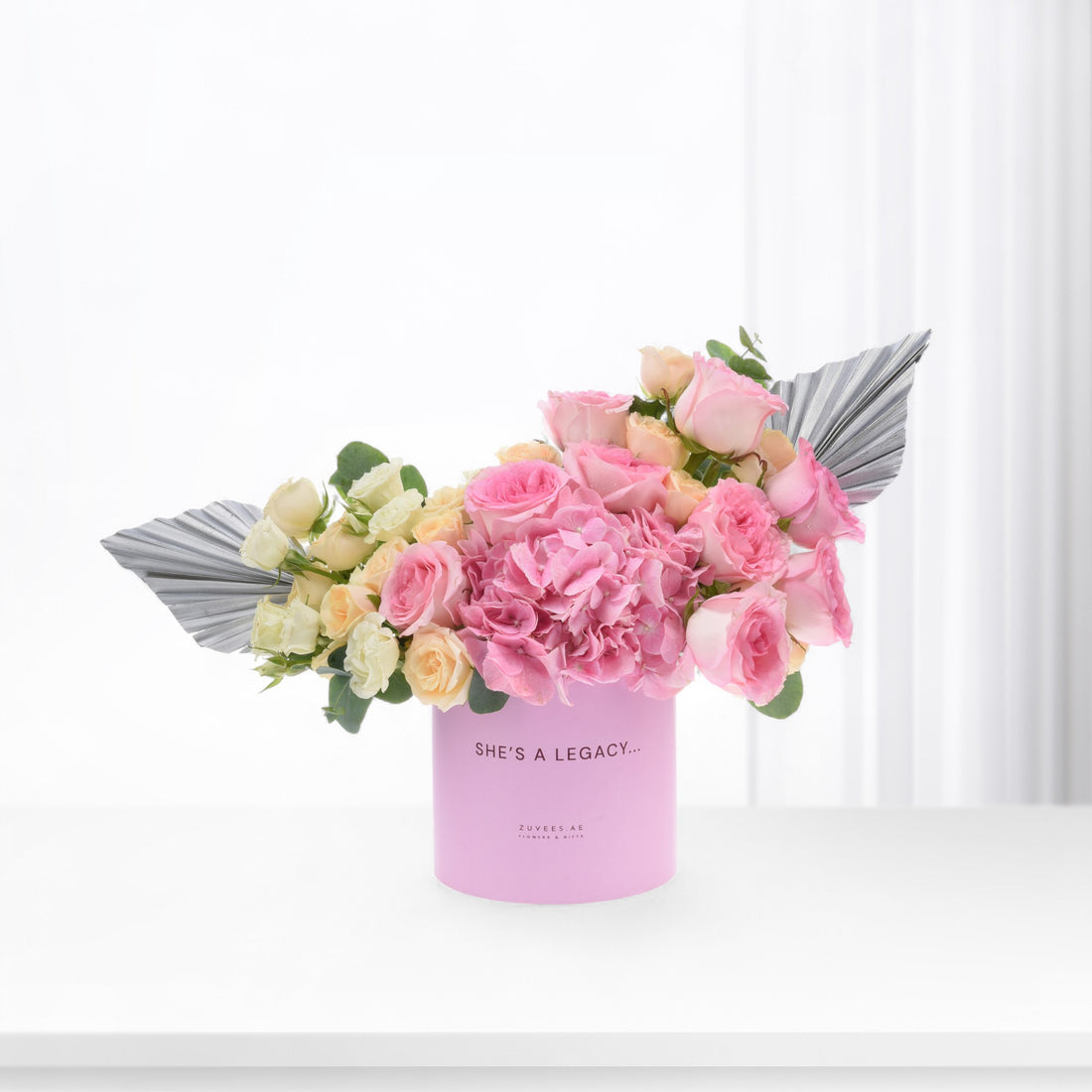 Pink rose and hydrangea bouquet in pastel pink box with silver leaf accents.