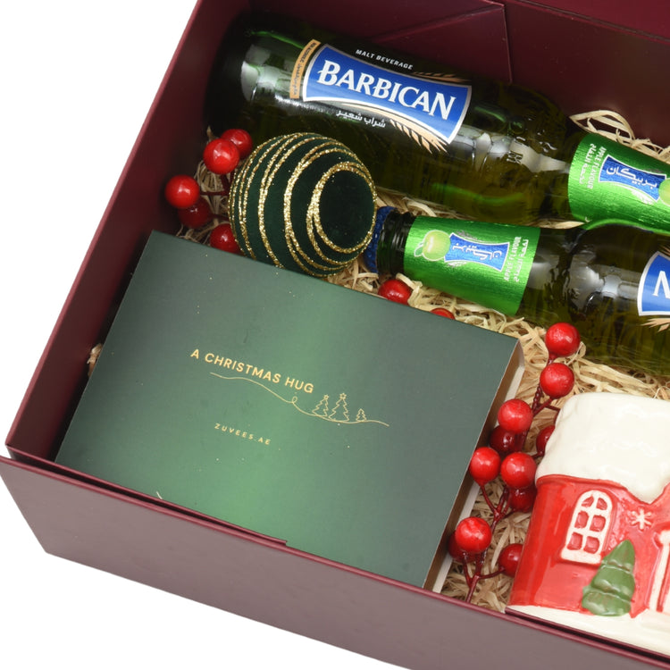 Maroon gift box holds Barbican malt bottles, festive decor, and "A Christmas Hug" card.
