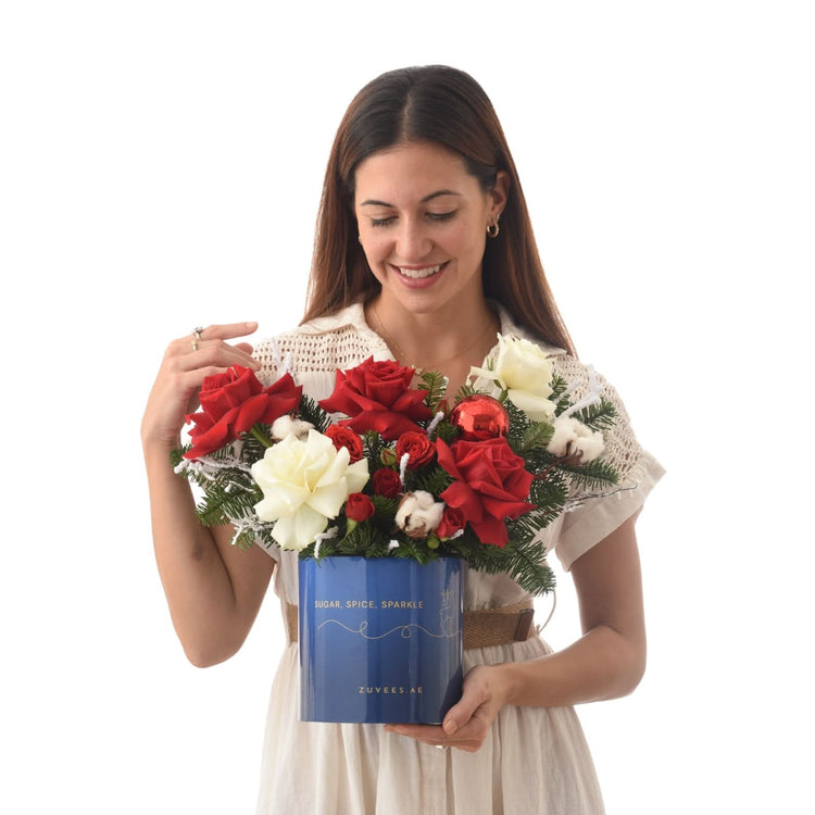 Woman smiles holding festive red and white rose bouquet in blue "Sugar, Spice, Sparkle" box.
