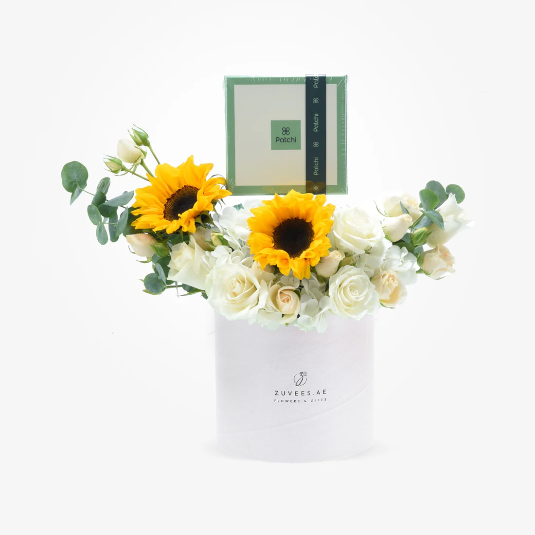 Vibrant sunflowers and white roses in sleek white box with branded chocolate gift.