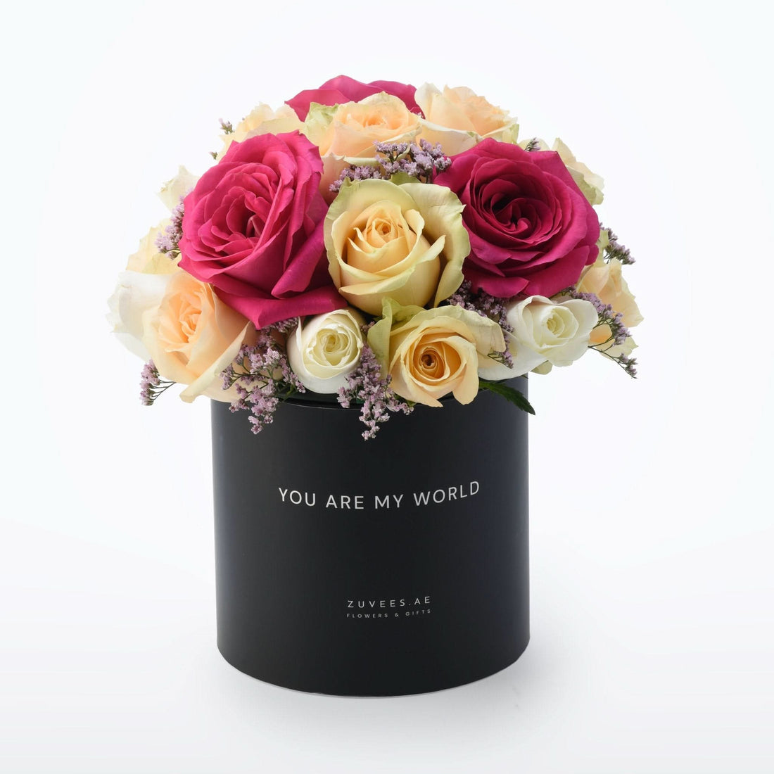 Vibrant pink, cream, and yellow roses with purple filler in sleek black "YOU ARE MY WORLD" box.