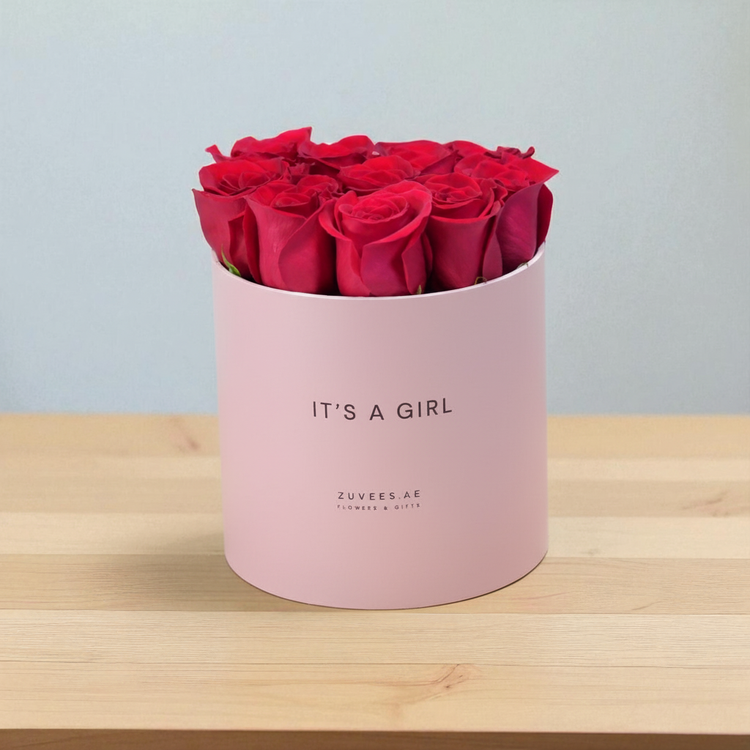 Vibrant red roses in soft pink box reading "IT&