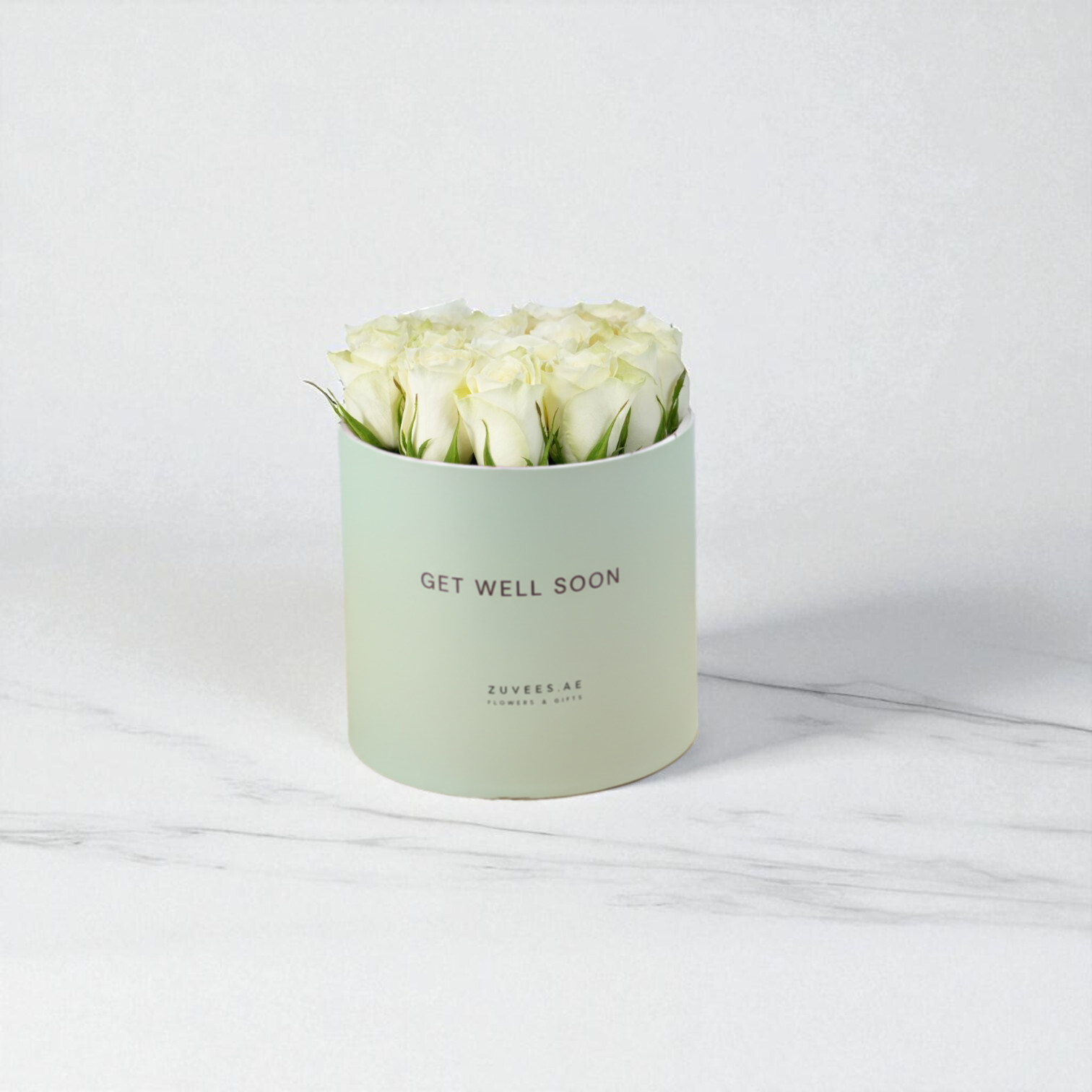 Pastel green box holds creamy white roses, “Get Well Soon” message.