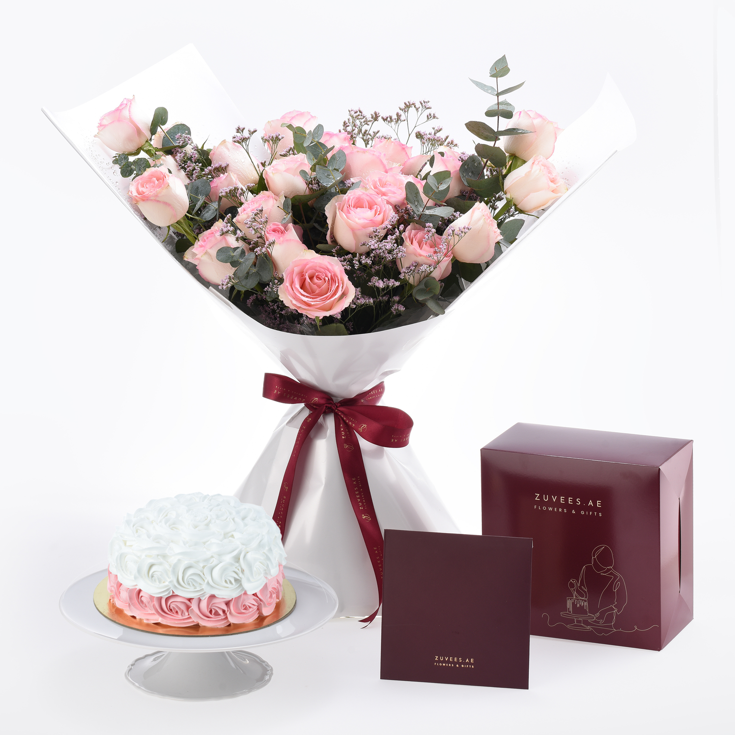 Soft pink roses and cake elegantly paired with burgundy gift boxes.