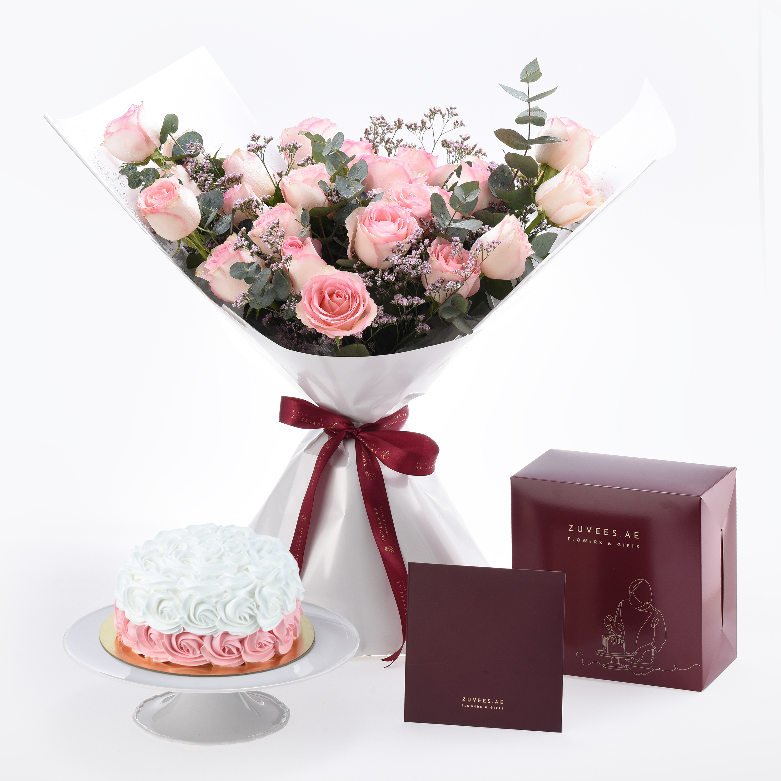 Soft pink roses and cake elegantly paired with burgundy gift boxes.