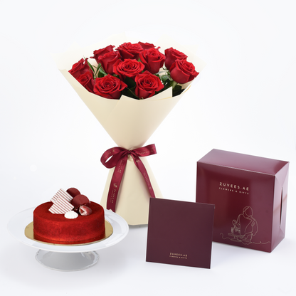 Vibrant red roses in cream wrap with burgundy ribbon, paired with red velvet cake and branded gift box.